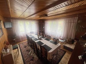 a dining room with a long table and chairs at Domek Pod Skansenem in Białowieża