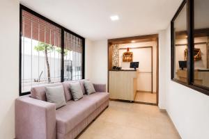 a living room with a couch and a window at FabHotel Ateethi Residency in Pune +26 photos