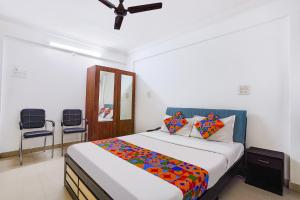 a bedroom with a bed and two chairs at FabHotel Ateethi Residency in Pune