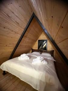a bed in a log cabin with towels on it at Сади Вітрів in Oriv