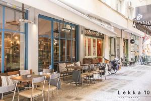 アテネにあるLekka 10 Apartmentsの通りにテーブルと椅子が並ぶレストラン