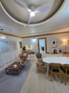 a living room with a ceiling with a table and chairs at 홍쓰 오션뷰 in Hakch'ŏn-dong