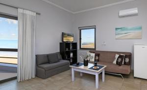 a living room with a couch and a table at Nefeli Rooms in Agia Marina Nea Kydonias