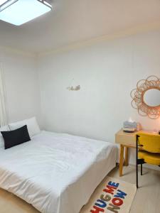 a bedroom with a bed and a desk and a mirror at 홍쓰 오션뷰 in Hakch'ŏn-dong