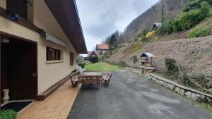 a building with a table and benches next to a hill at La Staulette in Queige