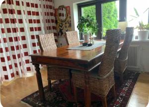 a dining room table with wicker chairs around it at Sjörups Vera in Trelleborg