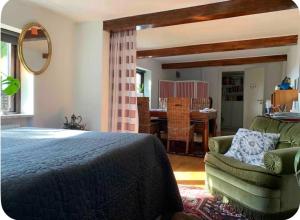 a bedroom with a bed and a chair and a table at Sjörups Vera in Trelleborg