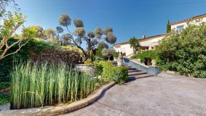 a house with a garden with a fence and grass at Casa Dina in Sommières