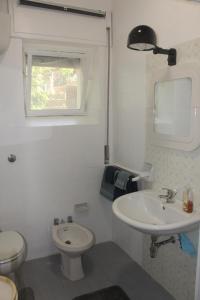 a white bathroom with a sink and a toilet at Villa Torre in Acquafredda +79 photos