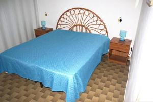 ein Schlafzimmer mit einem blauen Bett und zwei Nachttischen in der Unterkunft bilo giuggianello by salentolimit in Torre Lapillo