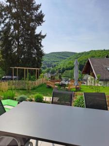 a table and chairs with a view of a garden at Ferienwohnung Hahnenblick in Hahnenbach