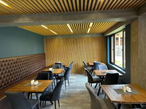 a dining room with wooden tables and chairs at Hotel Mansarda Mestia in Mestia