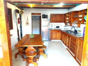a kitchen with a wooden table and a refrigerator at Black&White Brüäder in Puerto Ayora