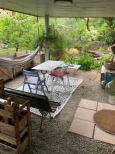 a patio with a table and chairs and a hammock at La chambre de la maison bleue in Colmar