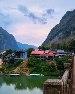 a group of houses on a hill next to a river at Vinla Guesthouse & Backpackers Hostel in Nongkhiaw