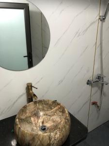 a bathroom with a stone sink and a mirror at LYNH HOUSE - Đồng Văn in Dồng Văn
