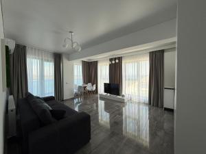 a living room with a couch and a television at Seaside Escape - Luxury Apartment in Năvodari
