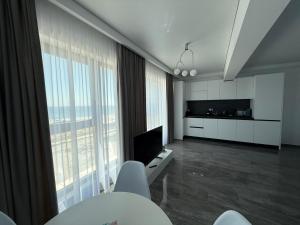 a living room with white furniture and a large window at Seaside Escape - Luxury Apartment in Năvodari