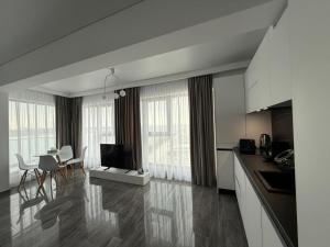 a kitchen and living room with a television and a table at Seaside Escape - Luxury Apartment in Năvodari