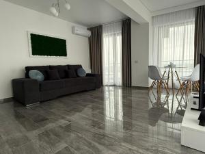 a living room with a couch and a table at Seaside Escape - Luxury Apartment in Năvodari +11 photos