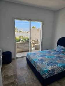 a bedroom with a bed and a view of a patio at Penthouse sarra in Kelibia