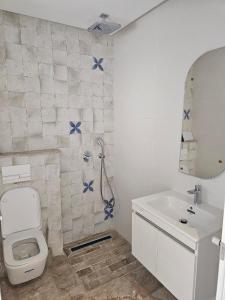 a bathroom with a shower and a toilet and a sink at Penthouse sarra in Kelibia