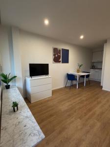 a living room with a table and a tv in it at City Apartment in Lörrach