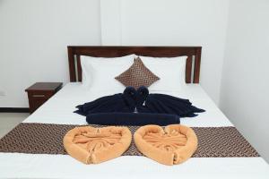 a bed with two heart shaped pillows on it at Polhena Neptune Resort in Matara
