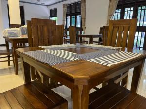 a wooden table in a room with wooden chairs at Polhena Neptune Resort in Matara +15 photos
