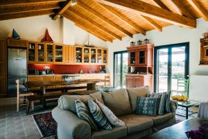a living room with a couch and a kitchen at The Englishman's Villa Evia in Perivólia