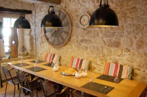 a dining room with a large clock on the wall at Le 2 in Vence