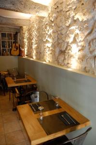 a dining room with two tables and a stone wall at Le 2 in Vence