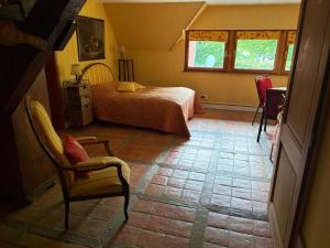 a bedroom with a bed and a chair at Relais Équestre du Neufeld - Suite ÉTÉ in Oberhaslach