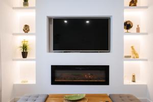 a living room with a tv above a fireplace at Luis Montoto in Seville +73 photos