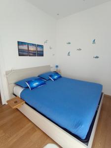 a bedroom with a large bed with blue pillows at A Casa Di Dona in Rimini