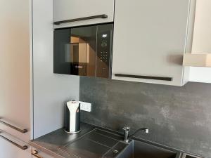 a kitchen with a sink and a microwave at apments - Premium Apartments nahe Hamburg in Rosengarten