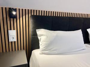 a bed with a white pillow and a black headboard at apments - Premium Apartments nahe Hamburg in Rosengarten +19 photos