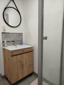 a bathroom with a sink and a mirror at Petite maison meublée in Landévant
