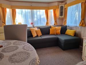 a living room with a couch in front of a window at Ezüst fenyő vendégház in Borzont