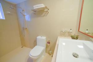 a white bathroom with a toilet and a sink at Hathaa Beach Maldives in Hulhumale