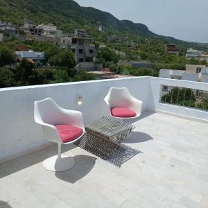 two chairs and a bench on a roof at Littlhouse in Rafrāf