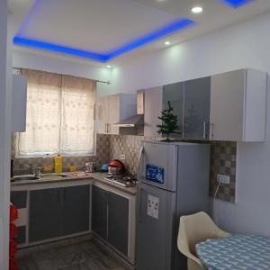 a small kitchen with a refrigerator and a sink at Littlhouse in Rafrāf