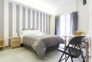 a bedroom with a bed and a table and a desk at Lekka 10 Apartments in Athens