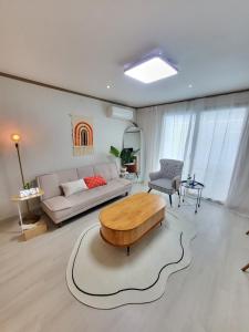 a living room with a couch and a table at 씨하우스 501호 in Hakch'ŏn-dong