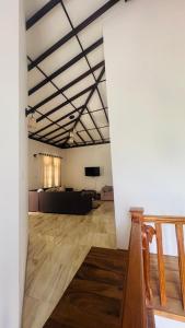 a large room with a white wall and wooden floors at Ceylon Mist Villa in Narandanda