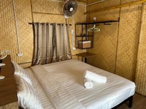 a bed with two towels on it in a room at Baan Bamboo Koh Tao in Ko Tao