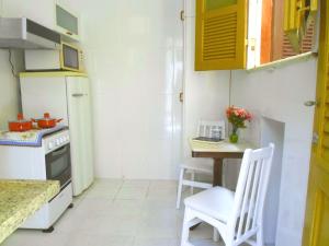 a small kitchen with a table and a refrigerator at Casa do Jardim in Rio de Janeiro