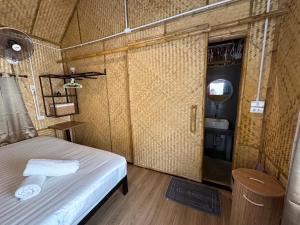 a small room with a bed and a mirror at Baan Bamboo Koh Tao in Ko Tao +2 photos