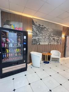 a restaurant with a drink refrigerator and two chairs at COLIBRI in Calella