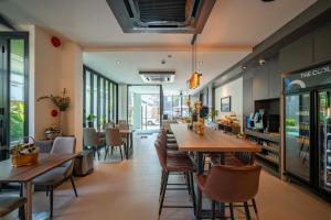 a restaurant with wooden tables and chairs and windows at Pim Old Town in Chiang Mai